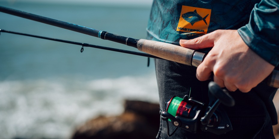 Pescador con caña y reel Masterguil en el mar